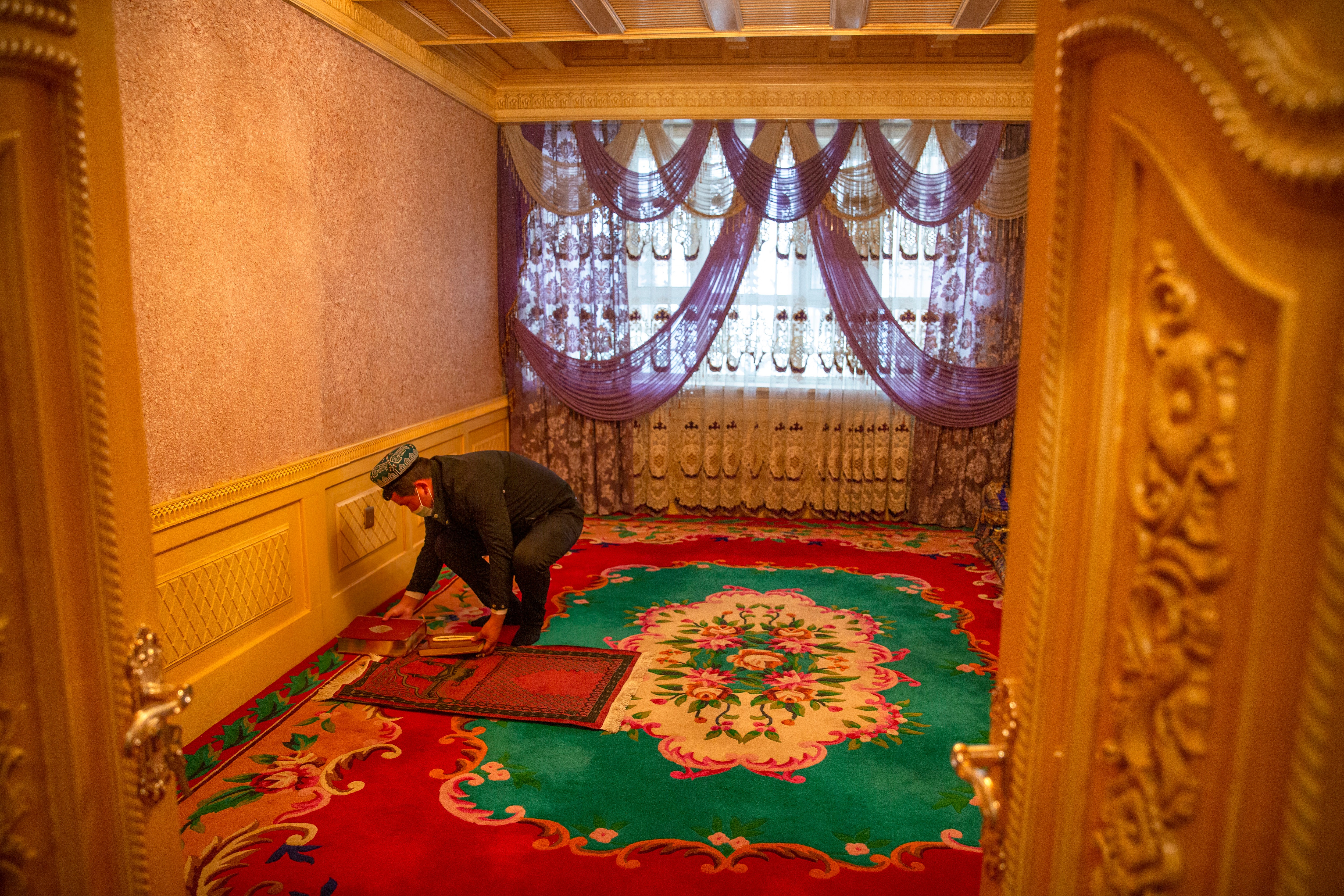 Tursunjan Mamat sets down a copy of the Quran during a government organized visit for foreign journalists to his home in Aksu in western China's Xinjiang Uyghur Autonomous Region on April 20, 2021. (AP) Tursunjan Mamat sets down a copy of the Quran during a government organized visit for foreign journalists to his home in Aksu in western China's Xinjiang Uyghur Autonomous Region on April 20, 2021. (AP)