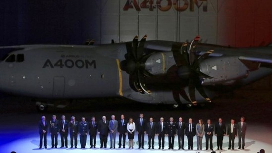 Spain's Crown Prince Felipe (C) poses for a family photo next to an Airbus A400M military transport plane during a ceremony at an assembly plant in the Andalusian capital of Seville. (Reuters Photo)