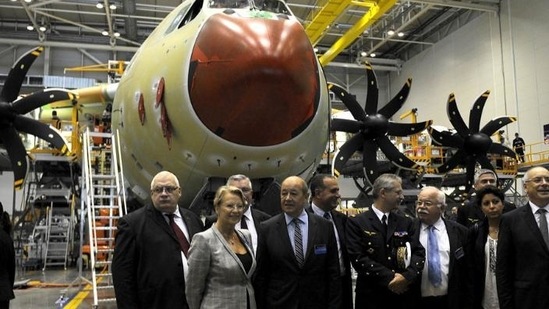 French defence minister Jean-Yves Le Drian (4thL), former French defence minister Michele Alliot-Marie (3rdL) and officials pose as they visit the A400M assembly line during the A400M First Delivery Ceremony in Sevilla. (AFP Photo)