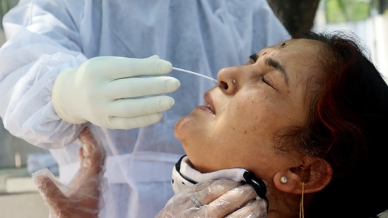 A medic collects a nasal sample of a woman for the Covid-19 testing amid the surge in coronavirus cases, at Gandhi Nagar Hospital, in Jammu.(ANI Photo)