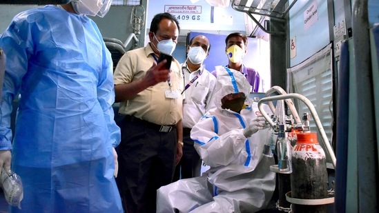 A health worker arranges oxygen cylinders inside an isolation train coach at Madan Mahal Railway station in Jabalpur, Madhya Pradesh on May 4. Currently, Madhya Pradesh is under a slew of restrictions to stem the spread of Covid-19. Chouhan said health infrastructure was being readied to deal with a possible third wave of infections.(ANI)