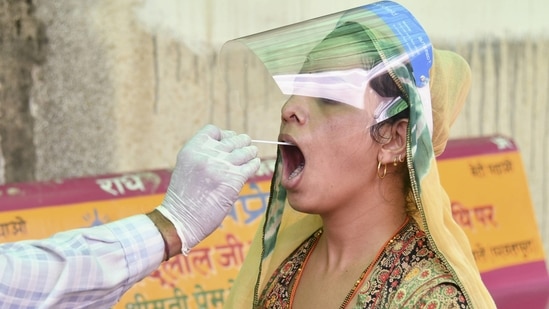 A health worker collects a swab sample from a woman for Covid-19 test in Ajmer, Rajasthan on May 4. The Rajasthan government has similarly has imposed a lockdown in the state from May 10 till May 24. Weddings have been banned till May 31, HT reported.(PTI )