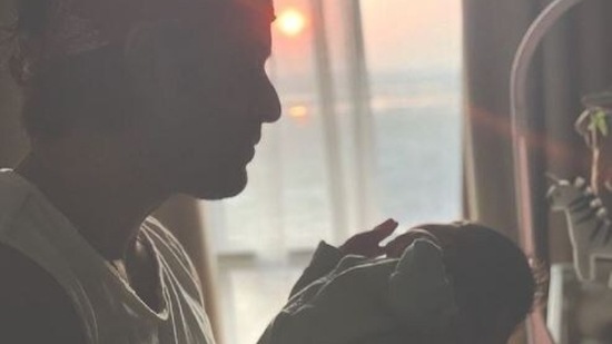 Mohit Malik holds his son as he shares his first glimpse with the world.