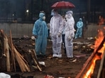 Relatives of a Covid-19 victim seen under an umbrella as it rains during a mass cremation in Seemapuri, New Delhi on May 6. According to a new analysis from the University of Washington’s Institute for Health Metrics and Evaluation (IHME), the Covid-19 pandemic has caused nearly 6.9 million deaths across the world, more than double the number officially recorded, Reuters reported.(Ajay Aggarwal / HT Photo)