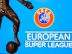 A metal figure of a football player with a ball is seen in front of the words "European Super League" and the UEFA logo in this illustration.