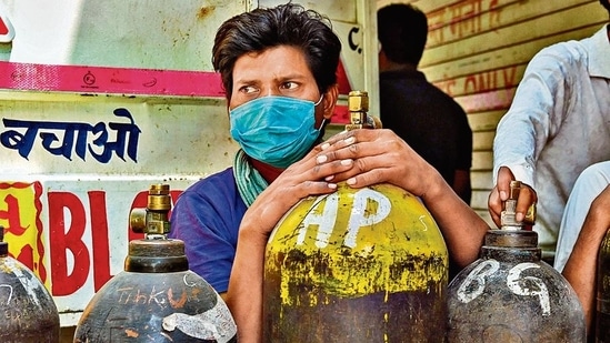 A man waits to refill oxygen cylinders for Covid-19 patients at a centre in New Delhi on Friday.(AFP)