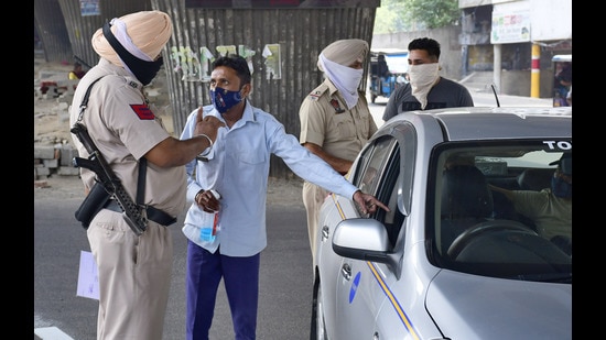 Police challaning a taxi driver for ferrying more than two passengers in Ludhiana on Sunday. (HARSIMAR PAL SINGH/HT)