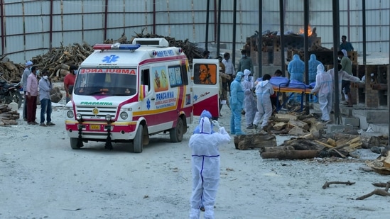 Family members and undertakers carry the body of a victim who died of the Covid-19 coronavirus at an open-air crematorium set up for the coronavirus victims inside a defunct granite quarry on the outskirts of Bangalore on May 8, 2021, as India recorded more than 4,000 coronavirus deaths in a day for the first time. 