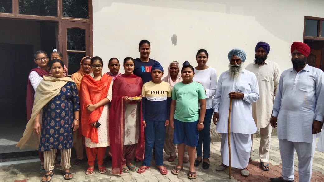 Kamalpreet with her family at her house in village Kabarwala(HT Photo)
