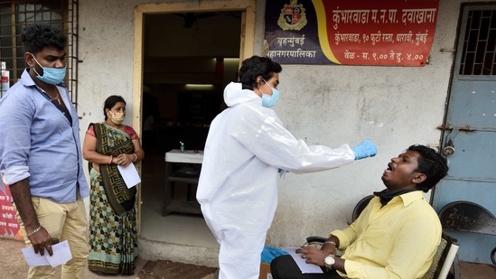 A BMC healthcare worker collects swab samples of the people at Dharavi in Mumbai, India.(Satish Bate/HT Photo) A BMC healthcare worker collects swab samples of the people at Dharavi in Mumbai, India.(Satish Bate/HT Photo)