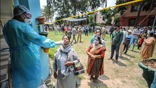 A health worker collects a swab sample for Covid test in Jammu on Monday. (PTI) A health worker collects a swab sample for Covid test in Jammu on Monday. (PTI)
