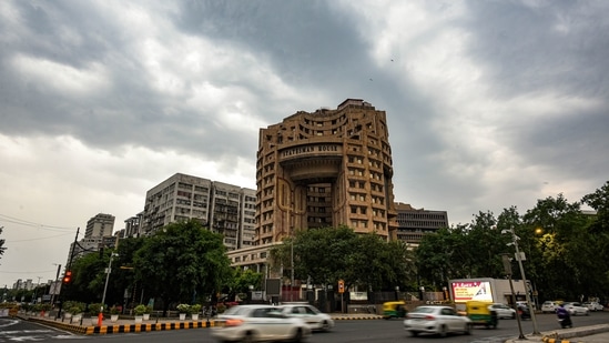 Vehicles move past the Statesman House building on an overcast day in New Delhi on May 6. With the May 9 announcement, Delhi has extended its lockdown for the third consecutive time, although this is the first instance of restrictions being tightened in this wave. The new restrictions will remain in place till 5am on May 17.(Amal KS / HT Photo)