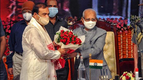 Assam Governor Jagdish Mukhi greets the new chief minister Himanta Biswa Sarma during his swearing-in ceremony at Srimanta Sankaradev Kalakshetra in Guwahati on Monday, May 10. (PTI)