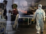 A health worker walks past Covid-19 patients inside a banquet hall temporarily converted into a Covid care centre in New Delhi on May 10. Delhi chief minister Arvind Kejriwal on May 10 said the national capital is preparing for the third wave of Covid-19 by augmenting infrastructure to a level where the city will be able to handle as many as 30,000 daily cases.(Arun Sankar / AFP)