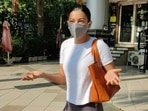 Gauahar Khan smiles from under her mask for the cameras.