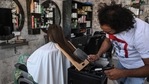 In this picture taken on April 8, 2021, Pakistani barber Ali Abbas uses a butcher knife to cut the hair of a customer at his shop in Lahore. - Hoping to prove a cut above the competition, Pakistani barber Ali Abbas relies on an unusual array of tools to practice his craft -- including blowtorches, meat cleavers, and even broken glass. (AFP) In this picture taken on April 8, 2021, Pakistani barber Ali Abbas uses a butcher knife to cut the hair of a customer at his shop in Lahore. - Hoping to prove a cut above the competition, Pakistani barber Ali Abbas relies on an unusual array of tools to practice his craft -- including blowtorches, meat cleavers, and even broken glass. (AFP)