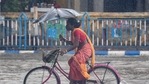 A woman holds her umbrella and wades her bicycle through a water logged road, after heavy rain in Kolkata, Tuesday, May 11, 2021. (PTI) A woman holds her umbrella and wades her bicycle through a water logged road, after heavy rain in Kolkata, Tuesday, May 11, 2021. (PTI)