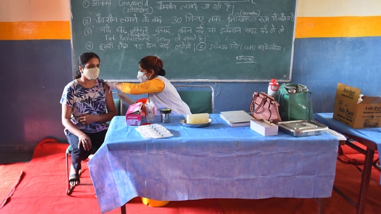 A health worker inoculates a person with a Covid-19 vaccine, at a government school in Vinod Nagar, New Delhi on May 10. Experts now believe the city will need to accelerate the vaccination campaign in order to avoid a crisis as the one seen in recent weeks if it wants to allow businesses, offices and shops to reopen.(Raj K Raj / HT Photo)