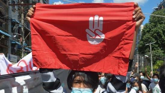 An anti-coup protester holds a slogan bearing the three-finger salute during a demonstration in Yangon, Myanmar. (AP) An anti-coup protester holds a slogan bearing the three-finger salute during a demonstration in Yangon, Myanmar. (AP)
