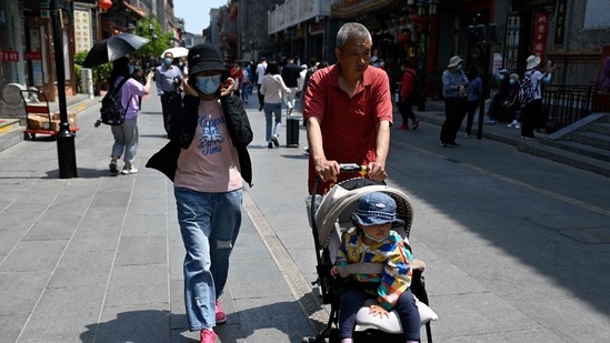A family walk along a street in Beijing. (AFP) A family walk along a street in Beijing. (AFP)