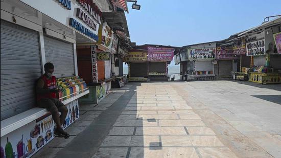 A man sits outside a closed shop during restrictions imposed by the Maharashtra government amid rising Covid-19 cases, in Mumbai. (File photo) A man sits outside a closed shop during restrictions imposed by the Maharashtra government amid rising Covid-19 cases, in Mumbai. (File photo)