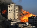 Smoke and flames rise from a tower building as it is destroyed by Israeli air strikes amid a flare-up of Israeli-Palestinian violence, in Gaza City May 12, 2021. 