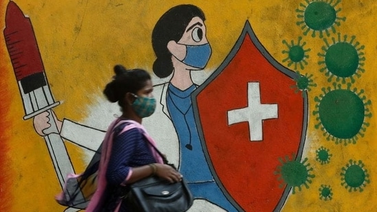 A woman walks past a graffiti on a street, amidst the spread of the coronavirus disease (Covid-19) in Mumbai, India,(Reuters)