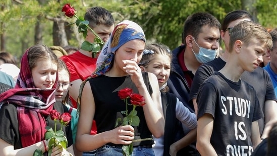 Mourners stand near the grave of Elvira Ignatieva, an English language teacher killed in the massacre at School Number 175, during a funeral at a cemetery in Kazan, Russia. (Reuters)