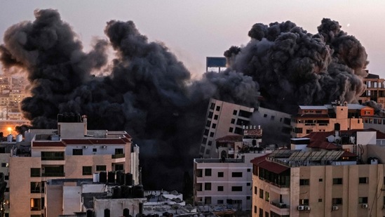 Smoke billows from an Israeli air strike on the Hanadi compound in Gaza City on May 11. In Gaza, one multi-story residential building, collapsed and another was heavily damaged after they were repeatedly hit by Israeli air strikes on May 12.(Mahmud Hams / AFP)