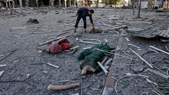 A Palestinian man inspects the debris outside the heavily-damaged Al-Jawhara Tower in Gaza City on May 12. "Israel has gone crazy," one man on a Gaza street told Reuters as explosions rocked the city.(Mahmud Hams / AFP)