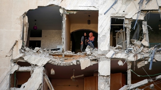 Palestinians look on as they inspect their residential building which was damaged in an Israeli air strike in Gaza City on May 12. Israel said its jets had targeted and killed several Hamas intelligence leaders early on May 12. Other strikes targeted what the military said were rocket launch sites, Hamas offices and the homes of Hamas leaders, Reuters reported.(Suhaib Salem / REUTERS)