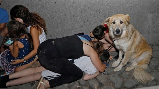 Israelis take cover under a bridge at the entrance of the central city of Tel Aviv on May 11 after rockets were launched by Hamas from the Gaza Strip controlled by the Palestinian Hamas movement. Many Israelis also spent a sleepless night, with sirens sounding at 3 am in Tel Aviv, heralding several waves of rocket strikes in Israel's heartland.(Gil Cohen-Magen / AFP)