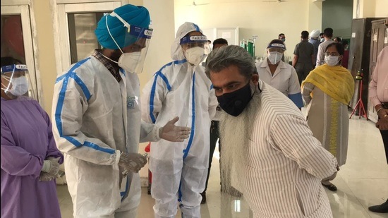 Bharat Bhushan Ashu (right) interacting with the medical staff at Covid facility in Ludhiana on Wednesday. (HT Photo)