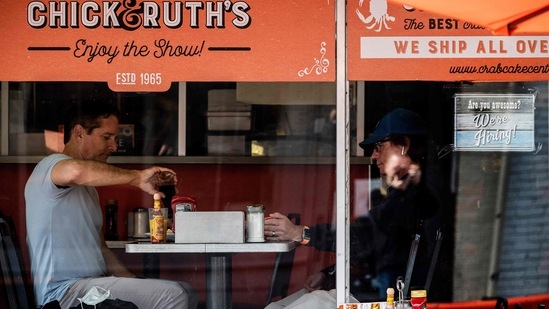 People eat breakfast at a restaurant that is advertising that they are hiring in Annapolis, Maryland, on May 12, 2021. (AFP) People eat breakfast at a restaurant that is advertising that they are hiring in Annapolis, Maryland, on May 12, 2021. (AFP)