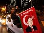 A pro-Palestinian demonstrator holds a flag with an image of Turkish President Tayyip Erdogan as they drive past by the Israeli Consulate in Istanbul, Turkey May 12, 2021. 