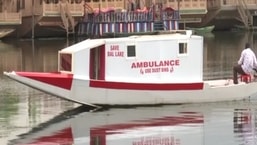 The image shows a boat ambulance on Dal Lake, Srinagar.