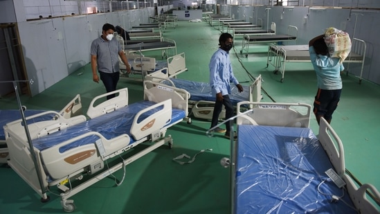 Workers setting up a 500-bed Covid-19 Care Centre at Ramlila Maidan in front of LNJP hospital, in New Delhi, on May 11. Delhi has added over 7,000 beds for Covid-19 patients since the second week of April, of which nearly 2,000 were ICU beds, according to the data on the government’s Delhi Corona app.(Ajay Aggarwal / HT Photo)