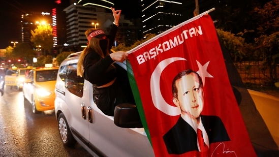 A pro-Palestinian demonstrator holds a flag with an image of Turkish President Tayyip Erdogan as they drive past by the Israeli Consulate in Istanbul, Turkey May 12, 2021. (Dilara Senkaya / REUTERS)