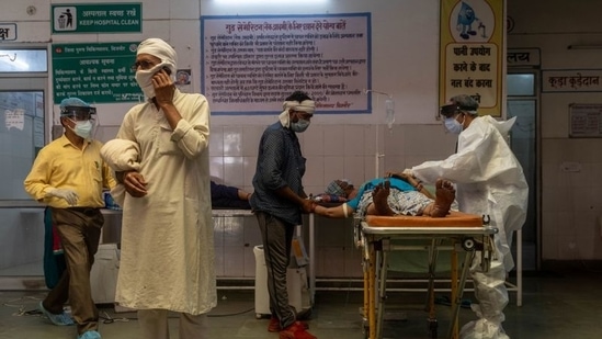A man speaks on the phone as a doctor tries to revive his wife inside an emergency ward of a government-run hospital, amidst the coronavirus disease (COVID-19) pandemic, in Bijnor district, Uttar Pradesh, India, May 11, 2021. (Representational purposed only)(REUTERS)