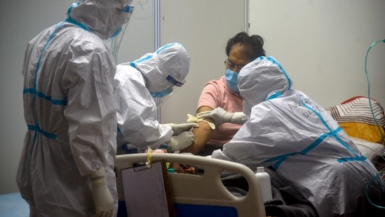 Health workers treat Covid- 19 Patient at CWG COVID care center in New Delhi on Thursday. (ANI Photo) Health workers treat Covid- 19 Patient at CWG COVID care center in New Delhi on Thursday. (ANI Photo)