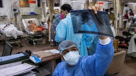 A resident doctor treating patients suffering from the coronavirus disease (COVID-19), looks at a patient's x-ray scan, at Holy Family Hospital in New Delhi, on May 1. Of the total 23,345 hospital beds in Delhi, 4,682 were vacant as on May 12 evening, putting the occupancy rate at 79.9%. Of the 5,911 ICU beds, 98 were vacant, putting the occupancy at 98.3%, HT reported.(Danish Siddiqui / REUTERS)