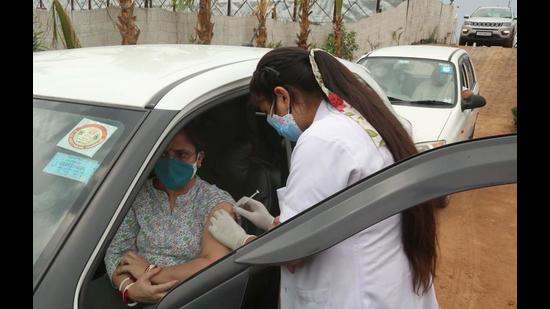 A medical professional administering a vaccine dose to a woman at a drive-through facility in Mullanpur. (Keshav Singh/HT) A medical professional administering a vaccine dose to a woman at a drive-through facility in Mullanpur. (Keshav Singh/HT)