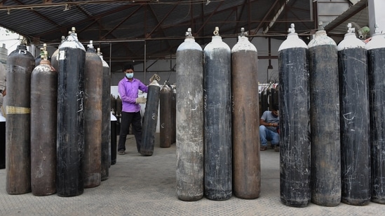 Employees refilling cylinders with medical oxygen at an oxygen plant in Mayapuri industrial area, New Delhi, on May 12. This also means that the oxygen requirement of hospitals has also reduced. “Not only has the supply of oxygen been streamlined, the requirement itself has gone down,” a doctor from Burari hospital told HT.(Ajay Aggarwal / HT Photo)
