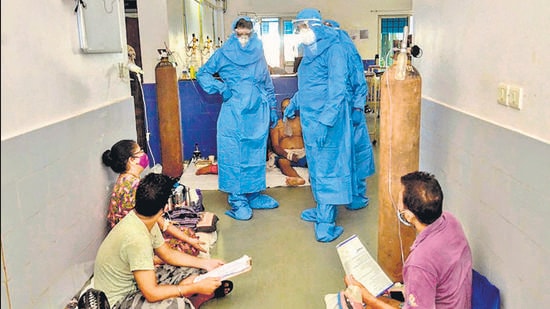 Goa CM Pramod Sawant (left), wearing a PPE suit, speaks to Covid-19 patients at the Goa Medical College, in Panjim. (AFP)