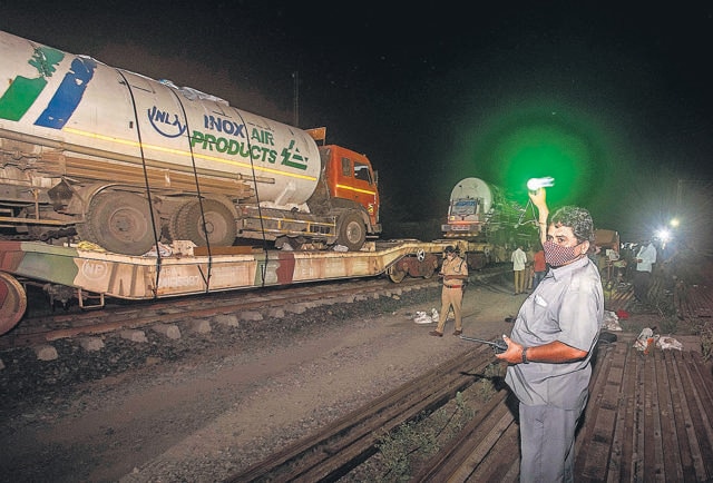 Railway pointsman Ambadas Pandu signals the motorman as the “Oxygen Express” arrives at the Loni railway station in Pune, on Wednesday at 12.30 am. (PRATHAM GOKHALE/HT) Railway pointsman Ambadas Pandu signals the motorman as the “Oxygen Express” arrives at the Loni railway station in Pune, on Wednesday at 12.30 am. (PRATHAM GOKHALE/HT)