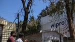 Employees enter a Wipro Ltd. office building in the Electronic City area of Bengaluru (Bloomberg file photo). Employees enter a Wipro Ltd. office building in the Electronic City area of Bengaluru (Bloomberg file photo).