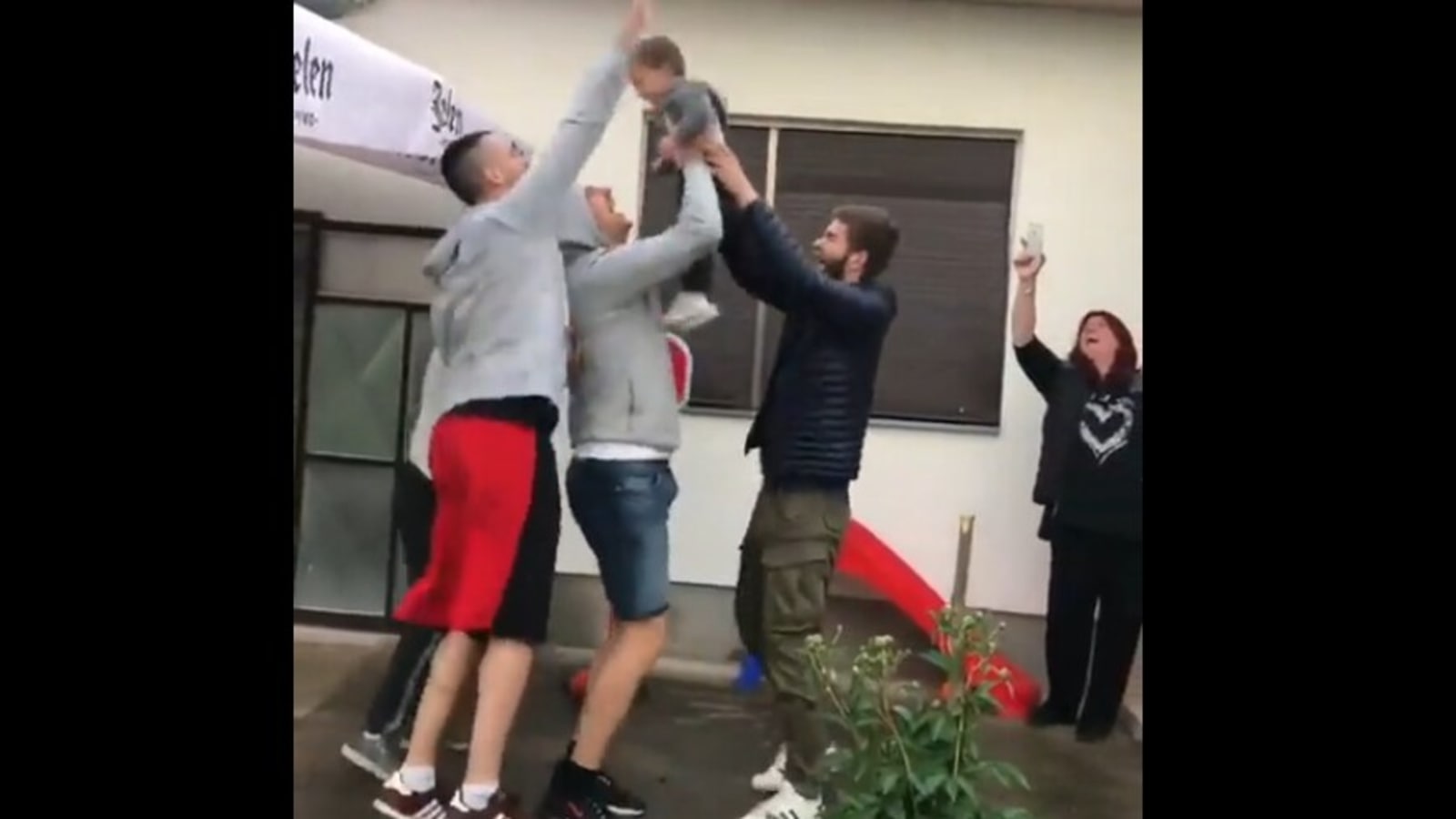 Grownups play basketball with kid, he scores and they celebrate. Watch