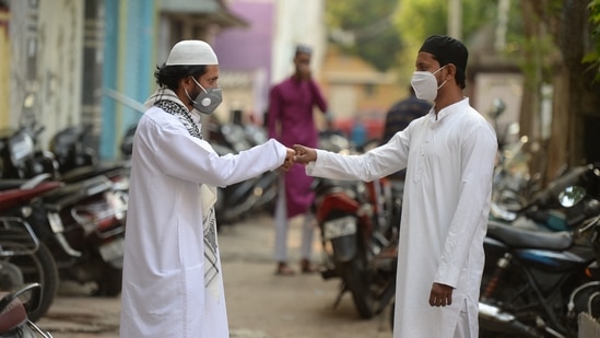 Men greet each other after offering prayers during Eid-al-Fitr festival, which marks the end of Islamic holy fasting month of Ramzan, outside their home during a Covid-19 induced lockdown, in Hyderabad on May 14. Amid a surge in Covid-19 cases, people in most parts of India offered namaz at their homes.(Noah Seelam / AFP)