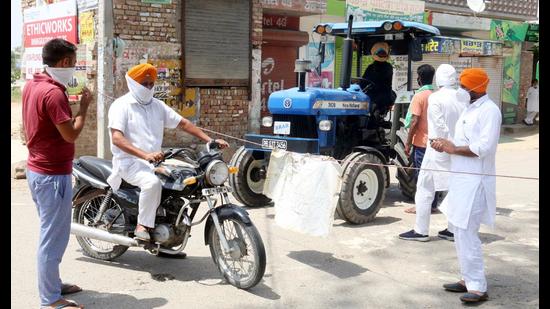 Villagers stopping a man from entering Bhokhra village in Bathinda on Friday. (Sanjeev Kumar/HT) Villagers stopping a man from entering Bhokhra village in Bathinda on Friday. (Sanjeev Kumar/HT)