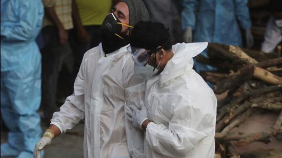 A grieving relative of a Covid-19 victim is consoled by another at a crematorium. As of May 13, there were over 2.62 lakh deaths in the country due to the pandemic. (AP PHOTO.) A grieving relative of a Covid-19 victim is consoled by another at a crematorium. As of May 13, there were over 2.62 lakh deaths in the country due to the pandemic. (AP PHOTO.)